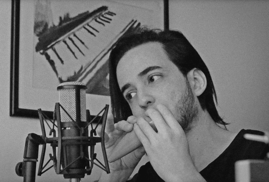 Eduardo playing an ocarina in front of a microphone